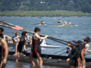 Rowers in the foreground exit Vancouver Lake after their races while others paddle out to the starting line Friday, May 19, 2023, during the U.S. Rowing Northwest Youth Championship Regatta at Vancouver Lake Park. The three-day event is expected to draw between 1,500 and 3,000 rowers over the course of the competition.