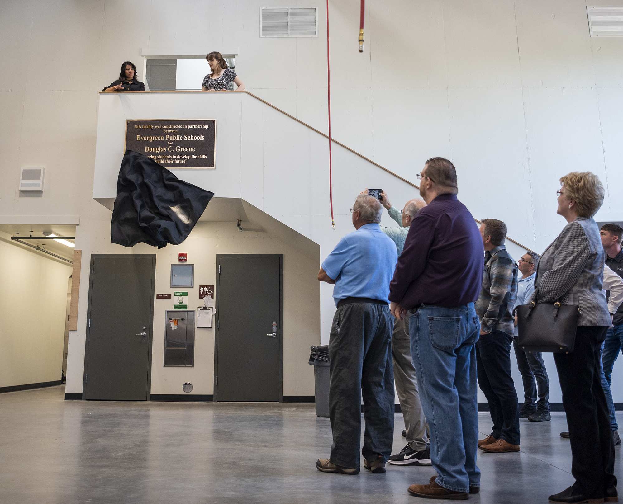 People watch as Evergreen students unveil a commemorative plaque Tuesday, May 16, 2023, during the grand opening of the Skilled Trades Center at Evergreen High School.