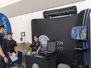 Vancouver Police Department Sgt. Danielle Wass, right, talks with officers Brandon Riedel, center, and Brandon Esau on Thursday at the Public Safety and First Responder Career Fair at Camp Withycombe in Clackamas, Ore.