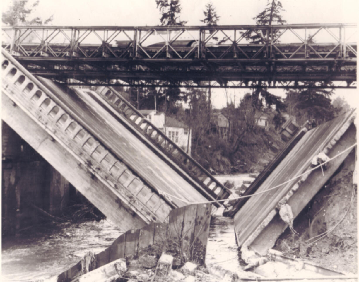 In early January 1956, heavy rains and melting snow supersaturated Clark County soil, creating landslides, washing out county roads, producing power outages and undermining the foundation of the Salmon Creek Bridge, causing it to collapse into a V-shape. The bridge failure halted Highway 99 travel in both directions until a temporary Bailey bridge from Fort Lewis restored traffic days later.