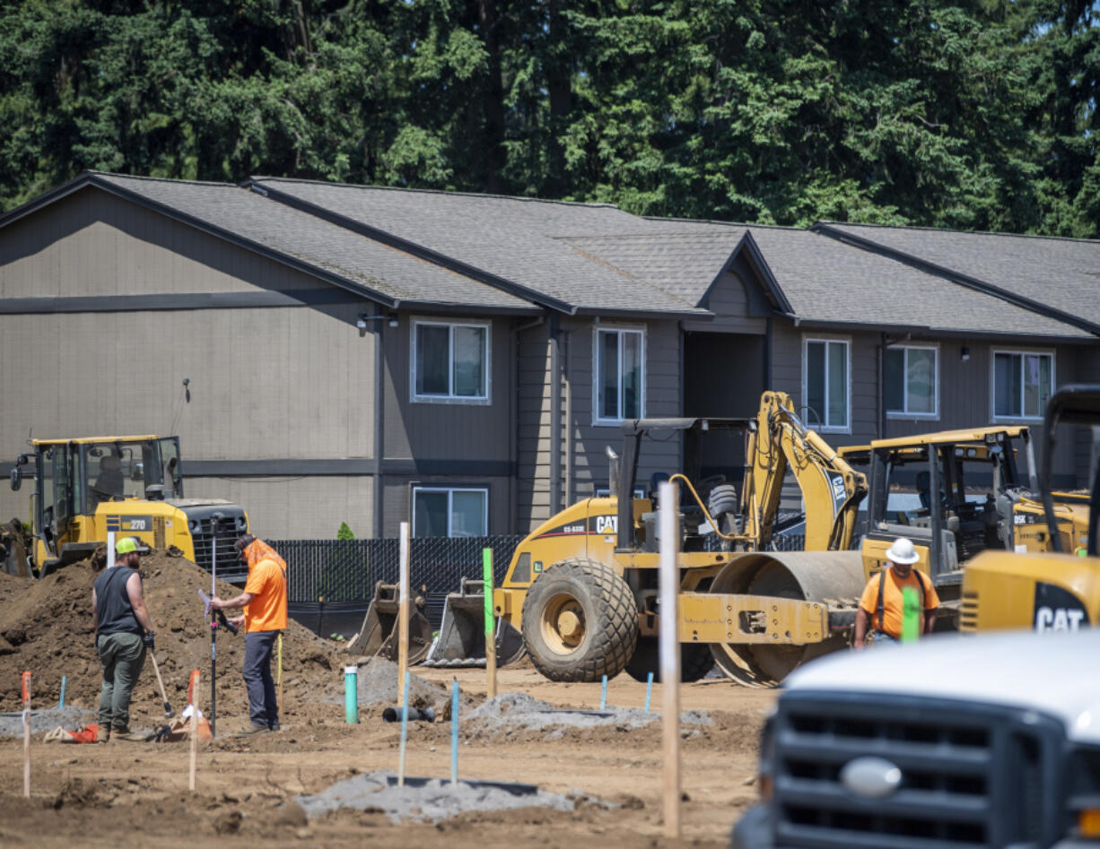Apartments look over construction vehicles on a site Friday along Northeast 138th Avenue in Vancouver.
