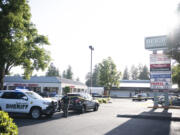 Clark County Sheriffs Office and Vancouver Police Department vehicles sit around police tape on Tuesday, May 30, 2023, at the site of a fatal shooting in the Heights Shopping Center parking lot.