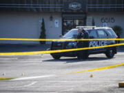 Crime scene tents mark where shell casings lie as Vancouver Police officers stand in the Heights Shopping Center parking lot on Tuesday, May 30, 2023, at the site of a fatal shooting.