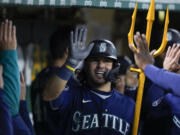 Seattle Mariners' Eugenio Suárez celebrates with teammates in the dugout after hitting a three-run home run against the Oakland Athletics during the 10th inning of a baseball game in Oakland, Calif., Wednesday, May 3, 2023. (AP Photo/Godofredo A.