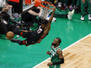 Miami Heat forward Jimmy Butler, left, dunks as Boston Celtics guard Jaylen Brown defends during the second half in Game 7 of the NBA basketball Eastern Conference finals Monday, May 29, 2023, in Boston.