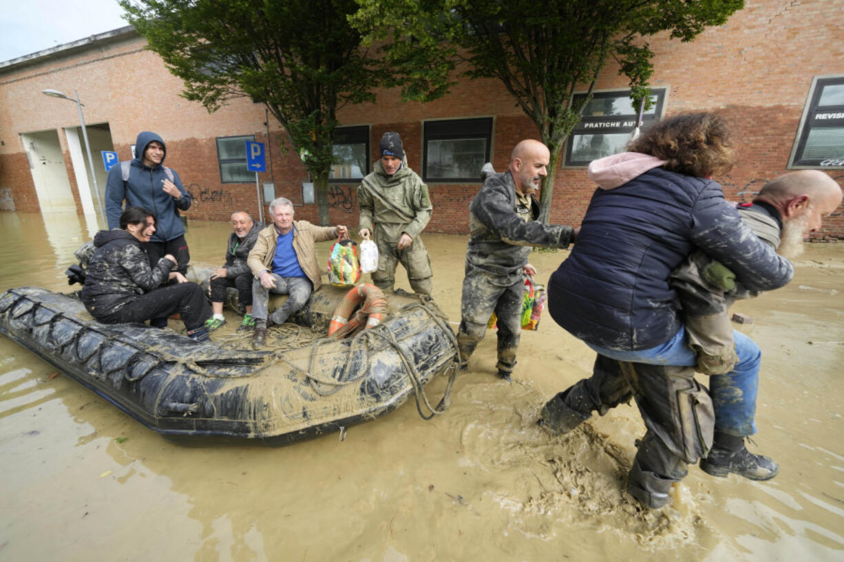 People are rescued in Faenza, Italy, Thursday, May 18, 2023. Exceptional rains Wednesday in a drought-struck region of northern Italy swelled rivers over their banks, killing at least nine people, forcing the evacuation of thousands and prompting officials to warn that Italy needs a national plan to combat climate change-induced flooding.