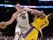 Denver Nuggets center Nikola Jokic (15) collides with Los Angeles Lakers forward LeBron James (6) in the second half of Game 4 of the NBA basketball Western Conference Final series Monday, May 22, 2023, in Los Angeles.