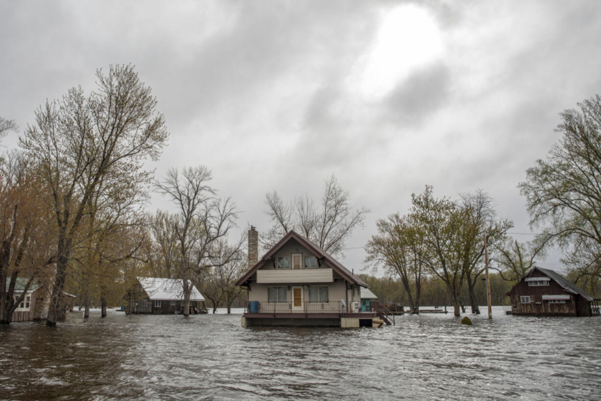 Cabins stand in high floodwaters on Bergman Island near McGregor, Iowa, Sunday, April 30, 2023. Community members worry that the high water could delay the start of the summer tourist season.