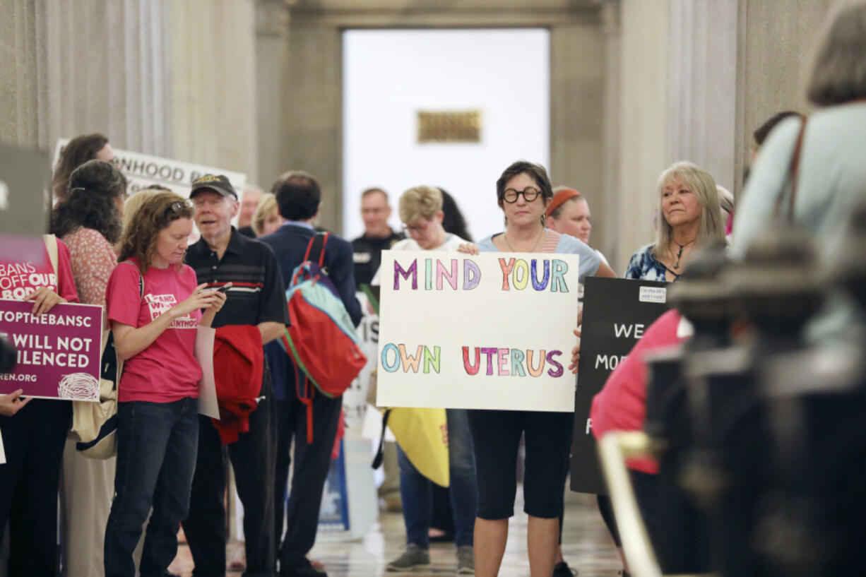 Protesters against a stricter ban on abortion in South Carolina stand in the Statehouse lobby on Tuesday, May, 23, 2023, in Columbia, South Carolina.