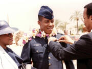 In this photo provided by the Brown family, retired Army Col. Charles Q. Brown, Sr., father, and his wife Kay Brown, pin Air Force wings onto the uniform of their son, 2nd Lt. CQ Brown, Jr., at his pilot training graduation at Williams Air Force Base, Ariz., in 1986.