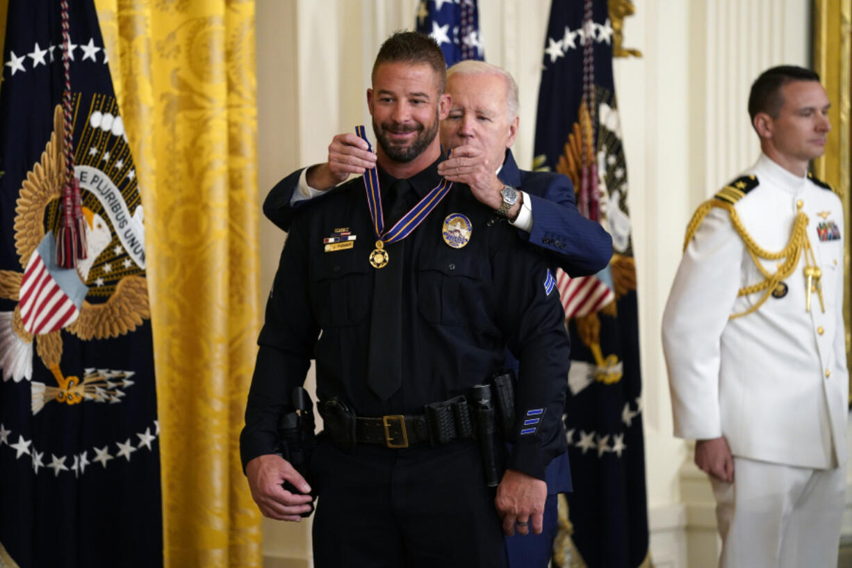 President Joe Biden presents the Medal of Valor, the nation's highest honor for bravery by a public safety officer, to Cpl. Jeffrey Farmer, of the Littletown, Colo., Police Dept., during an event in the East Room of the White House, Wednesday, May 17, 2023, in Washington.