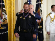 President Joe Biden presents the Medal of Valor, the nation's highest honor for bravery by a public safety officer, to Cpl. Jeffrey Farmer, of the Littletown, Colo., Police Dept., during an event in the East Room of the White House, Wednesday, May 17, 2023, in Washington.