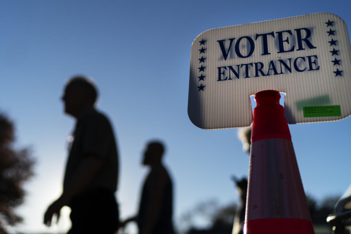 FILE - Voters pass a sign outside a polling site in Warwick, R.I.,, on Nov. 7, 2022, after casting their ballots on the last day of early voting before the midterm election. Almost half of all voters in the 2022 midterm elections cast their ballots before Election Day either by mail or through early voting, with Asian and Hispanic voters leading the way, new data from the U.S. Census Bureau released Tuesday, May 2, 2023, shows, even as Republican-led states have tightened rules on voting by mail.