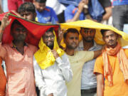 FILE - Cricket fans cover their heads with a long scarf to shield themselves from heat during an Indian Premier League (IPL) cricket match in Lucknow, India, April 22, 2023. A searing heat wave in parts of southern Asia in April this year was made at least 30 times more likely by climate change, according to a rapid study by international scientists released Wednesday, May 17.