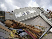 FILE - Jeremy Hodges climbs up the side of his family's destroyed storage unit in the aftermath of Hurricane Ida, Aug. 30, 2021, in Houma, La. National Oceanic and Atmospheric Administration on Thursday, May 25, 2023, announced its forecast for the 2023 hurricane season. (AP Photo/David J.