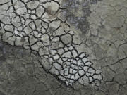 FILE - Dried cracked mud is visible at the Antelope Island Marina due to low water levels, Aug. 31, 2022, on the Great Salt Lake, near Syracuse, Utah. A new study Thursday, May 18, 2023, says climate change's hotter temperatures and society's diversion of water have been shrinking the world's lakes, including the Great Salt Lake, by trillions of gallons of water a year since the early 1990s.