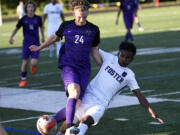 Columbia River's Tyler Brown (24) battles for possession of the ball with Foster's Anawar Kimo during River's 3-0 win in a Class 2A boys soccer state first-round playoff game at Columbia River High School on Wednesday, May 17, 2023.