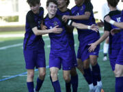 Columbia River players celebrate a goal by Alex Harris (center) during the Rapids' 3-0 win over Foster in a Class 2A boys soccer state first-round playoff game at Columbia River High School on Wednesday, May 17, 2023.