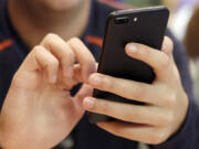 FILE - A person uses a smartphone in Chicago, Sept. 16, 2017. Most Democrats and Republicans agree that the federal government should better regulate the biggest technology companies, particularly social media platforms. But there is very little consensus on how it should be done.