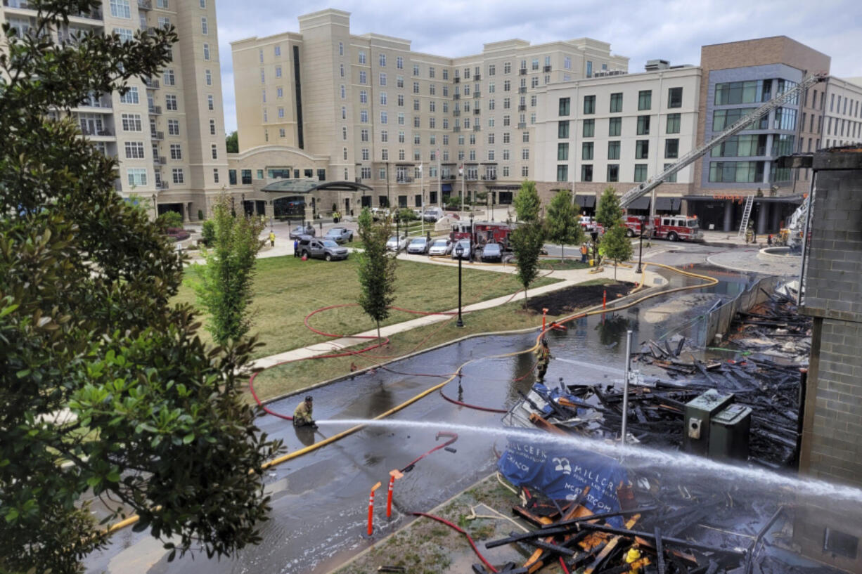 Firefighters work the scene of a massive fire spread across at least two structures and threatened others in Charlotte's South Park neighborhood, North Carolina, Thursday morning, May 18, 2023.