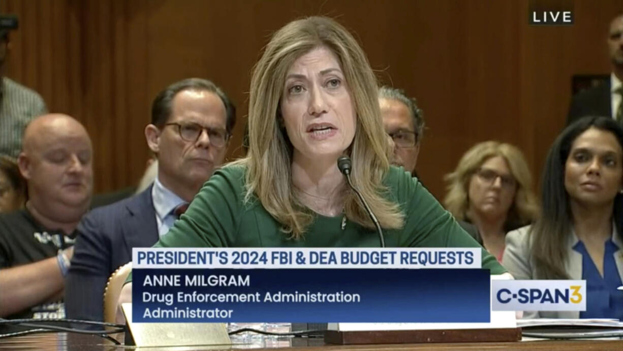 In this image from video provided by C-SPAN, U.S. Drug Enforcement Administration Administrator Anne Milgram speaks during a hearing before the Senate Appropriations Subcommittee on Commerce, Justice, and Science in Washington on May 10, 2023. At center left behind Milgram is Louis Milione. After temporarily leaving the DEA in 2017, like dozens of colleagues in the agency's powerful-but-little-known Office of Diversion Control, Milione immediately went to work as a consultant for some of the same companies he had been tasked with regulating, including Morris & Dickson. He was named deputy administrator in 2021. On another front, a federal watchdog is investigating whether Milgram improperly awarded millions of dollars in no-bid contracts to hire her past associates.