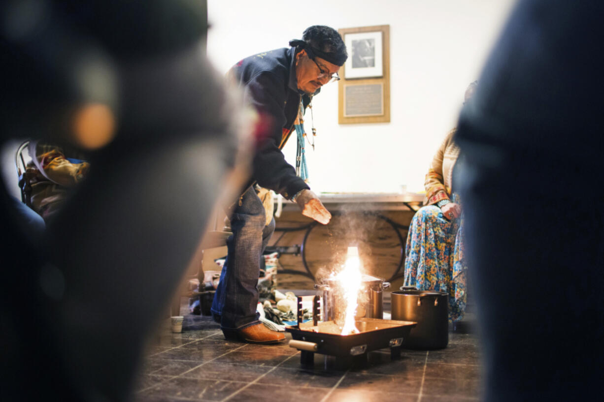 In this photo provided by Dartmouth College, Medicine Man Herbert Wilson, a citizen of the Din?, or Navajo Nation, from Thoreau, N.M, lights the ceremonial fire for the cleansing ceremony he was leading in Carpenter Hall at Dartmouth College, April 28, 2023, in Hanover, N.H. The college announced in March 2023 that it housed partial Native American skeletal remains in their collection. Dartmouth has set in motion an effort to repatriate the remains to the appropriate tribes.