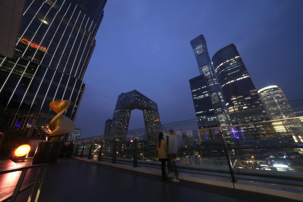 File - People linger in the Central Business District in Beijing, Wednesday, Oct. 26, 2022. If the debt crisis now roiling Washington were eventually to send the United States crashing into recession, the repercussions of a first-ever default on the federal debt would reverberate around the world and quickly.