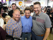 FILE - Florida Gov. Ron DeSantis, center, poses for a photo with audience members during a fundraising picnic forRep. Randy Feenstra, R-Iowa, May 13, 2023, in Sioux Center, Iowa. DeSantis is kicking off his presidential campaign in Iowa at the start of a busy week that will take him to 12 cities in three states as he tests his pitch as the most formidable Republican challenger to former President Donald Trump. (AP Photo/Charlie Neibergall.