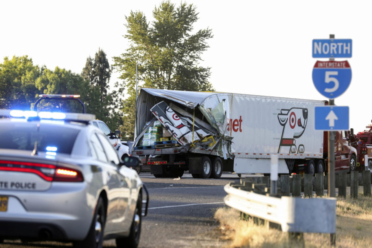 FILE - The back end of a semitruck sits along Interstate 5, Thursday, May 18, 2023, in Marion County, Ore. The semitruck driver involved in the crash on Interstate 5 earlier in the month that left seven farmworkers dead has been indicted on charges of manslaughter. Court documents show that a grand jury in Marion County Court on Tuesday, May 30, indicted Lincoln Smith on 12 counts, including manslaughter and driving under the influence.