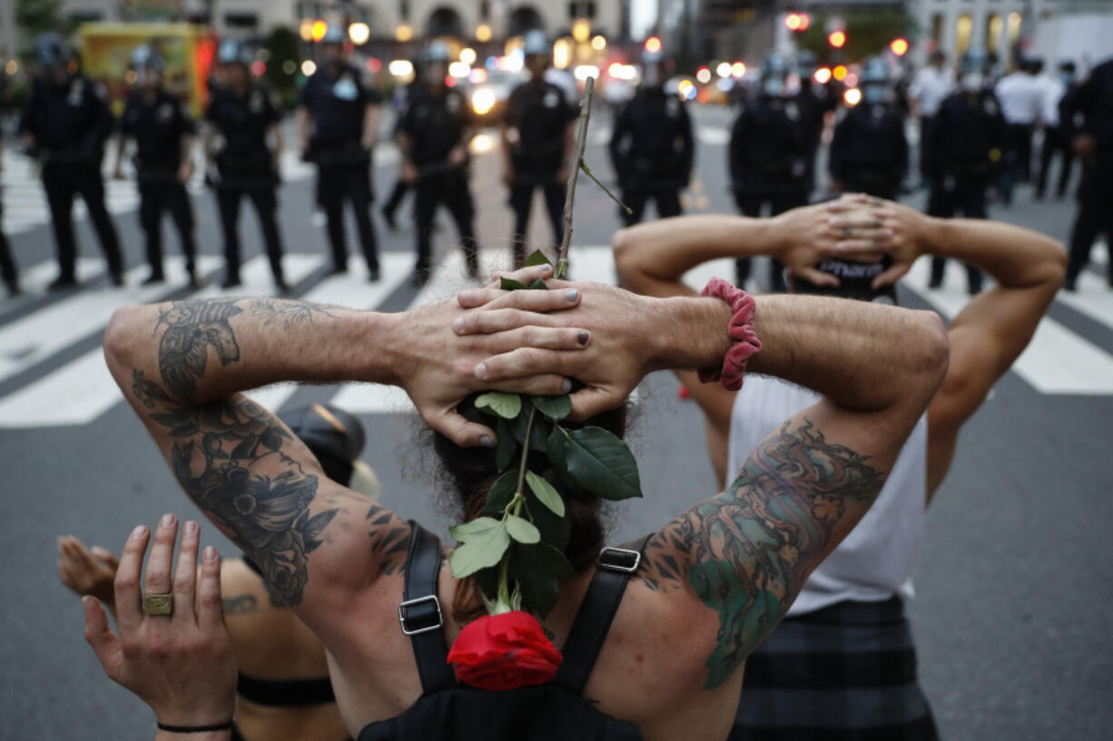 FILE - Protesters kneel in front of New York City Police Department officers before being arrested for violating curfew beside the iconic Plaza Hotel on 59th Street, June 3, 2020, in New York. Protests continued following the death of George Floyd, who died after being restrained by Minneapolis police officers on May 25. The third anniversary of Floyd's murder is Thursday, May 25, 2023.