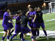 The members of the Heritage boys soccer team celebrate around Pablo Barbosa Sanchez (center) after he scored the overtime goal to beat Mountain View 1-0 at Heritage High School on Wednesday, May 3, 2023.