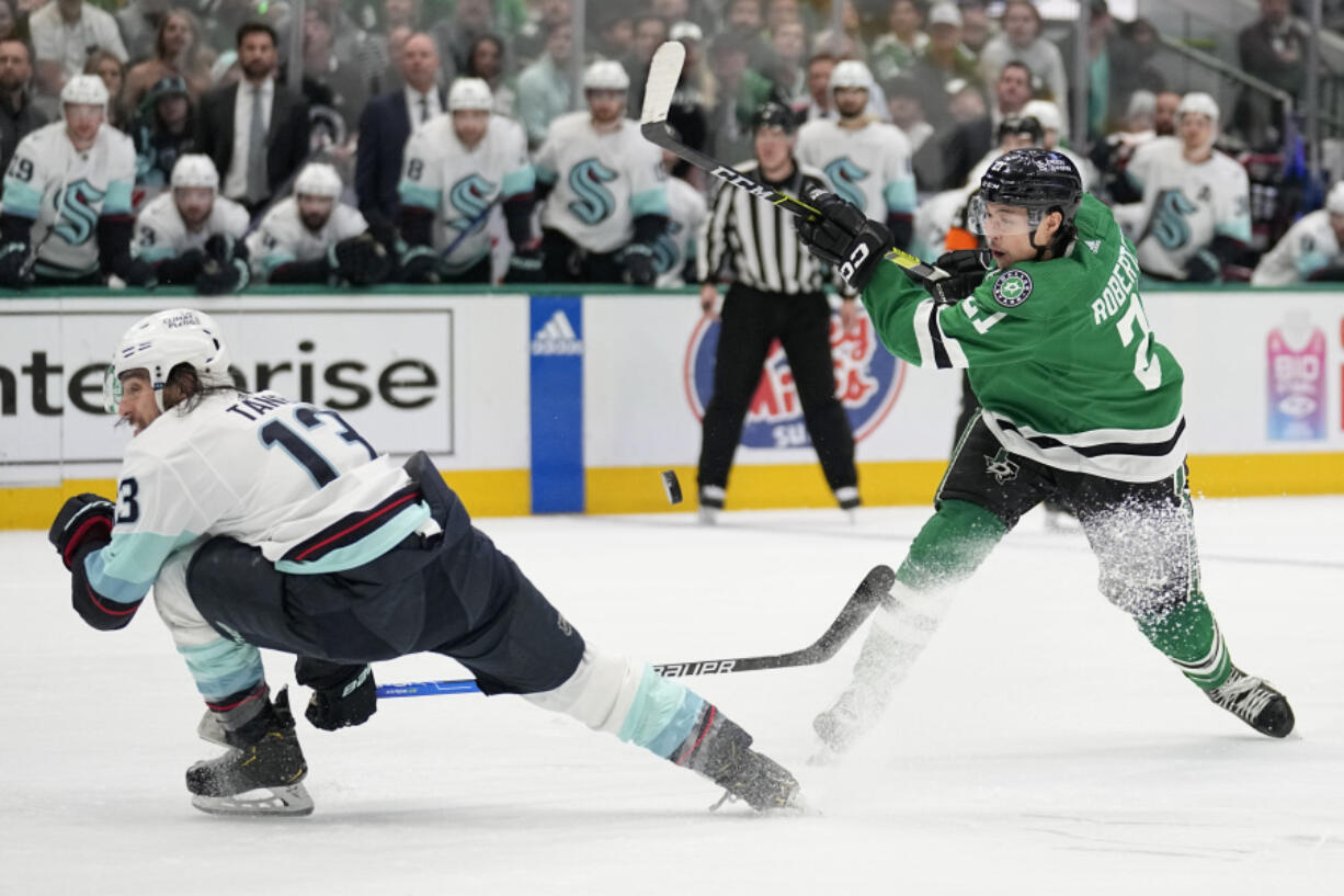 Seattle Kraken left wing Brandon Tanev (13) takes a hit from the puck on a shot by Dallas Stars left wing Jason Robertson (21) in the first period of Game 7 of an NHL hockey Stanley Cup second-round playoff series, Monday, May 15, 2023, in Dallas.