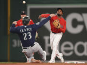 Boston Red Sox's Pablo Reyes, right, throws to first as Seattle Mariners' Ty France (23) slides out at second base in the sixth inning of a baseball game Wednesday, May 17, 2023, in Boston.