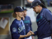 Seattle Mariners starting pitcher Bryce Miller, left, is greeted by pitcher Luis Castillo in the dugout after pitching sixth innings against the Oakland Athletics in a baseball game Wednesday, May 24, 2023, in Seattle.