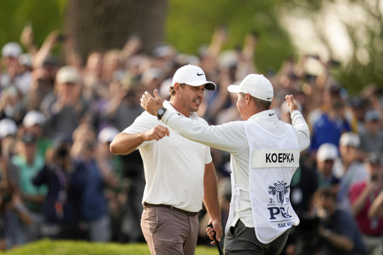 Brooks Koepka celebrates with his caddie Ricky Elliott after winning the PGA Championship at Oak Hill Country Club on Sunday in Pittsford, N.Y.