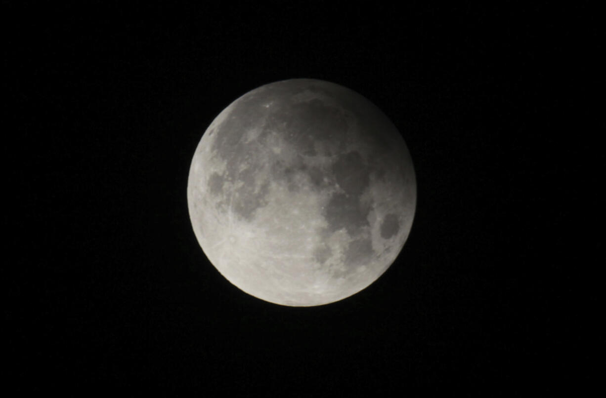 FILE - A penumbral lunar eclipse is seen from Lahore, Pakistan, on Feb. 11, 2017. Late Friday, May 5, 2023, into Saturday, May 6, stargazers in Asia and Australia were treated to a penumbral lunar eclipse, where the moon got only a bit darker and did not exhibit the hallmarks of a total lunar eclipse. (AP Photo/K.M.