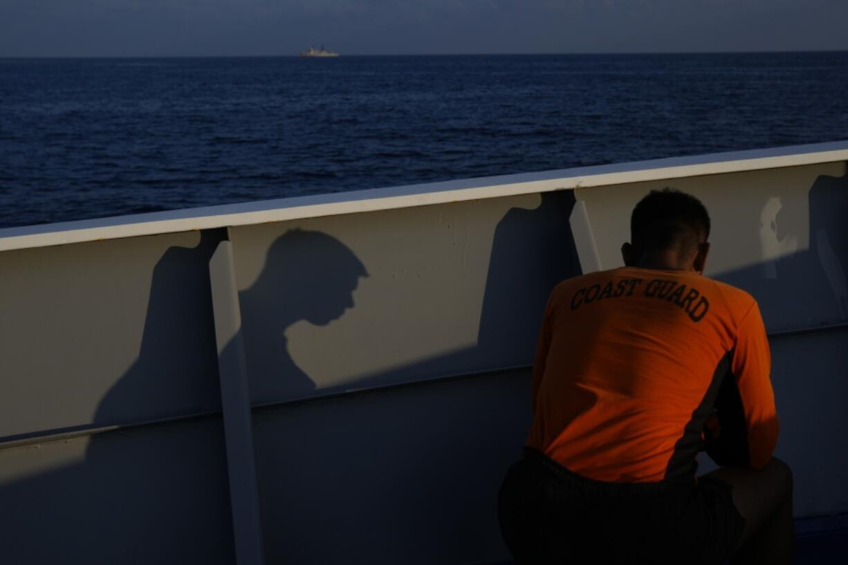 A member of the Philippine Coast Guard uses his mobile phone during a break onboard the BRP Malabrigo as they continue their patrol and resupply of troops at Philippine-occupied areas in the South China Sea on Friday, April 21, 2023 (AP Photo/Aaron Favila)