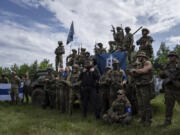 Fighters of Russian Volunteer Corps prepare for the press conference not far from the border in Sumy region, Ukraine, Wednesday, May 24, 2023. Russia's military said Tuesday it quashed what appeared to be one of the most serious cross-border attacks from Ukraine since the war began, claiming to have killed more than 70 attackers in a battle that lasted around 24 hours.