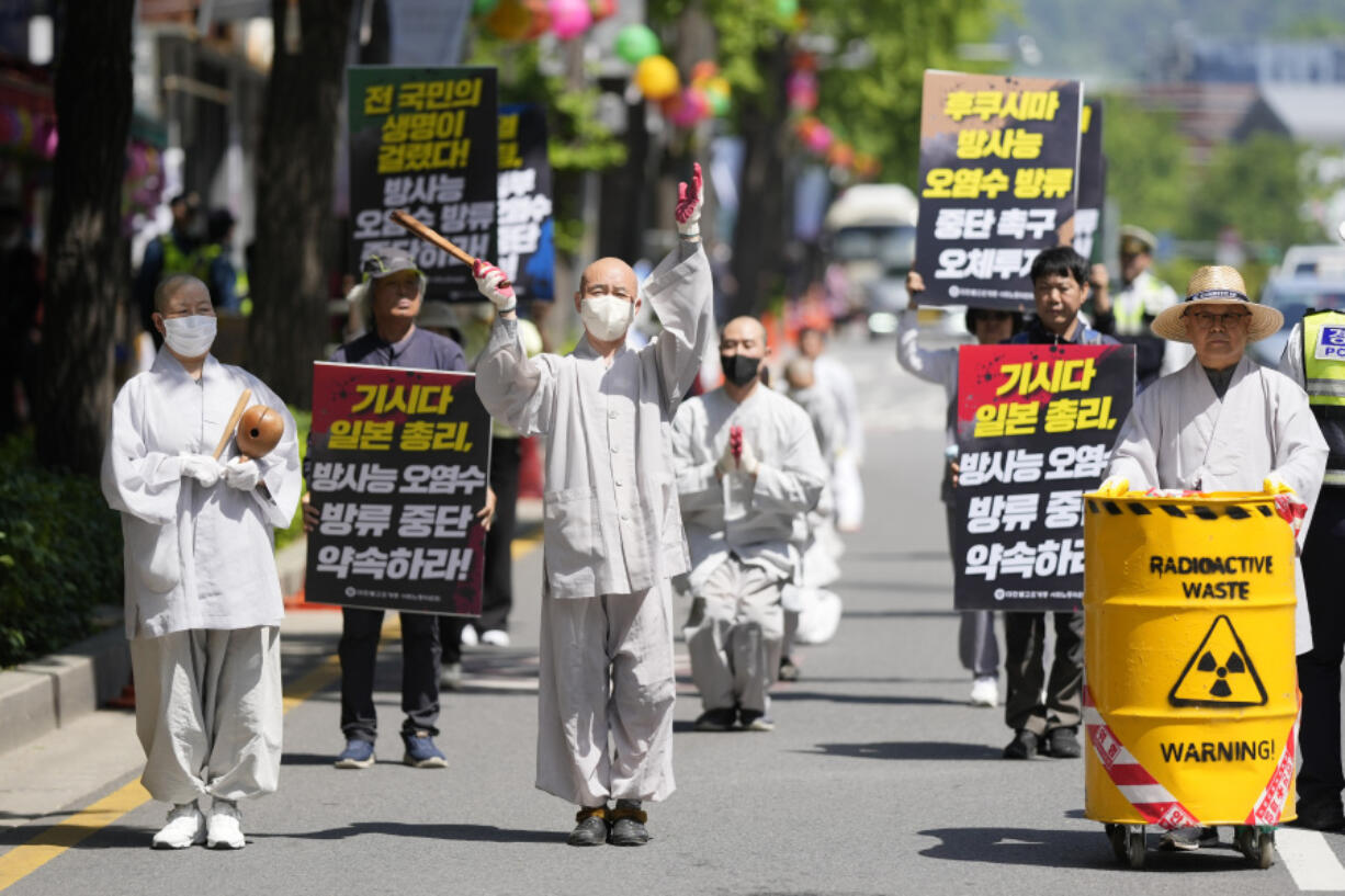 South Korean Buddhist monks, Buddhists and members of civic groups bow which they prostrate themselves, on a road in a march as they move toward to Japanese Embassy during a rally demanding the stop of Japanese government's decision to release treated radioactive water from the Fukushima, in Seoul, South Korea, Monday, May 8, 2023.