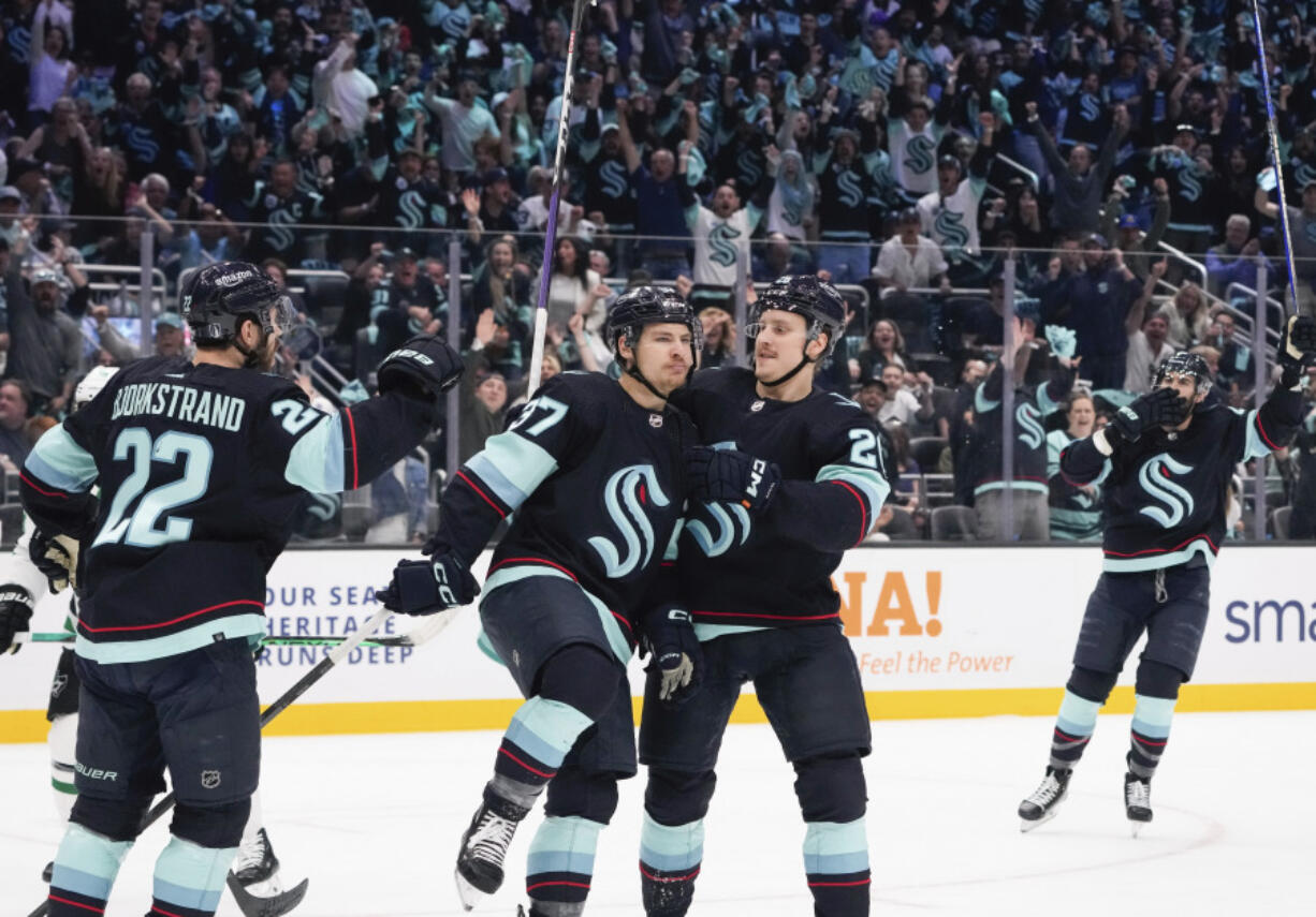 Seattle Kraken center Yanni Gourde (37) celebrates his goal against the Dallas Stars with Oliver Bjorkstrand (22) and Eeli Tolvanen (20) during the first period of Game 6 of an NHL hockey Stanley Cup second-round playoff series Saturday, May 13, 2023, in Seattle.