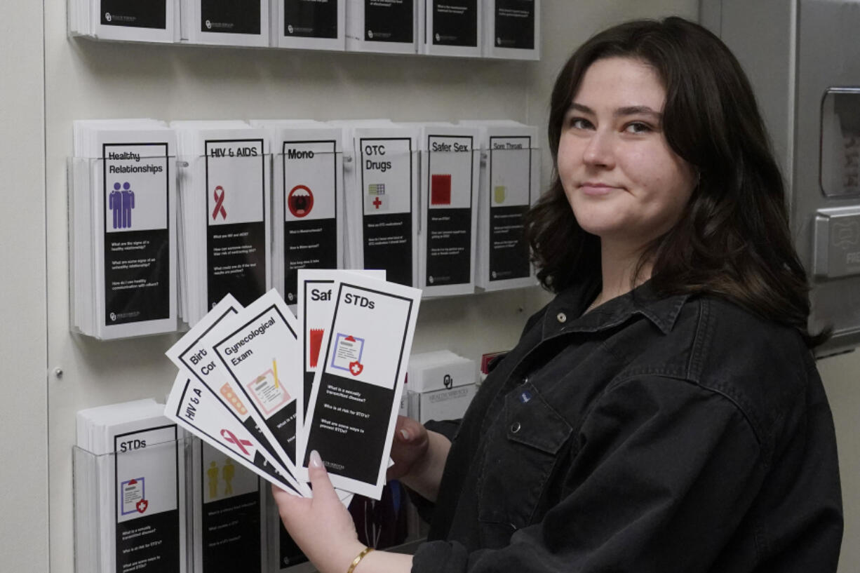 Abby Tow, a Sexual Health Peer Educator at the University of Oklahoma, displays some of the sexual health pamphlets available at the health center on campus, Wednesday, May 10, 2023, in Norman, Okla. Tow said she wonders if helicopter parenting has played a role in what she calls the "baby-fication of our generation".