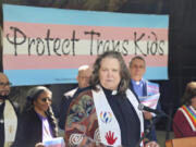 In this photo provided by Dirk Bolle, the Rev. Pat Langlois, senior pastor of MCC Church of Christ of the Valley, speaks at an interfaith rally in Pasadena, Calif., on March 31, 2023, protesting the wave of anti-transgender bills being enacted in numerous Republican-governed states. "These bills are the most vitriolic and cruel legislation I've seen," she said. "I have a non-binary teenager, so I take this really personally, not just as a person of faith and as a lesbian, but as a mom." Langlois, whose LGBTQ activism spans several decades, described the current situation as "probably the scariest time" because of the array of hostile bills.