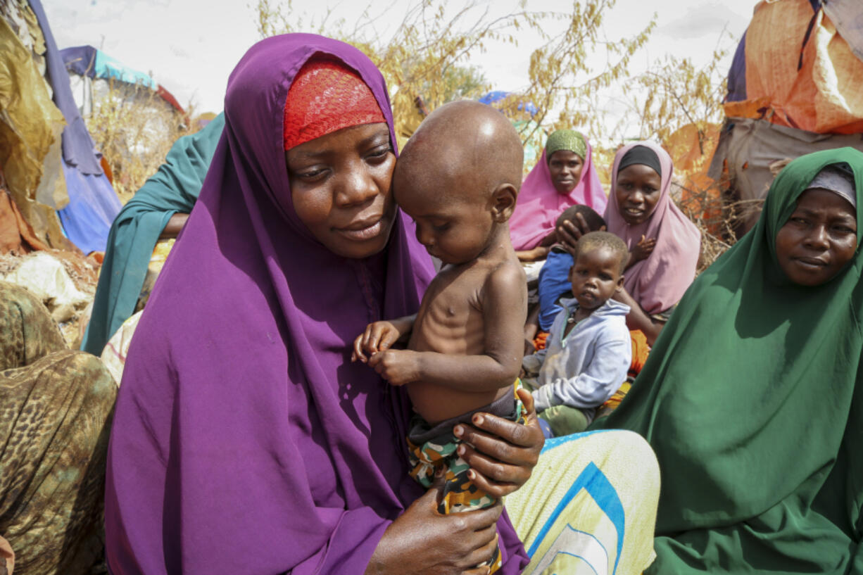 FILE - Nunay Mohamed, 25, who fled the drought-stricken Lower Shabelle area, holds her one-year old malnourished child at a makeshift camp for the displaced on the outskirts of Mogadishu, Somalia on June 30, 2022. More than a quarter-billion people in 58 countries faced acute food insecurity last year because of conflicts, climate change, the effects of the COVID-19 pandemic and Russia's war in Ukraine, according to a report published Wednesday, May 3, 2023.