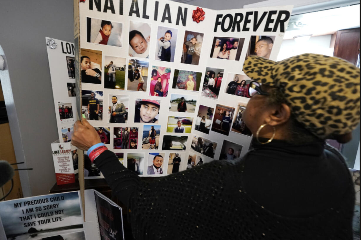 Bernice Ringo looks through photographs of her son Natalian, Tuesday, March 28, 2023, in Detroit. Ringo had hoped to move him away from the crime she had feared most of his life, but those plans crumbled when Natalian was fatally shot in 2019. The victim compensation program ultimately denied Ringo's application because they said her son had contributed to his murder.