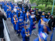 Graduates, in blue at left, and faculty, in black at right, walk into the RV Inn Style Resorts Amphitheater on Thursday, June 15, 2023, during the Clark College Commencement Ceremony.