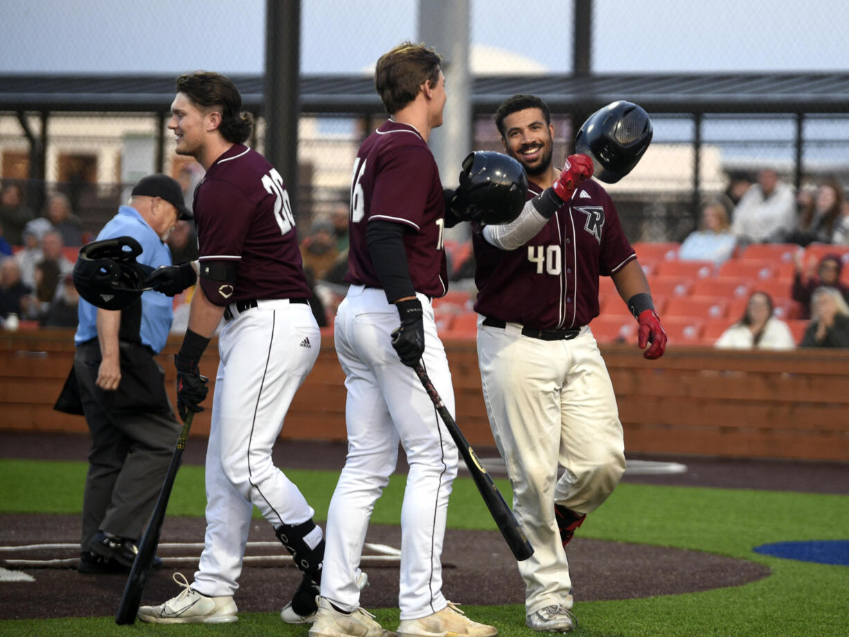 Ridgefield’s Isaac Lovings (40) is greeted at home plate by teammates Jack Salmon (16) and Jeff Hoffman (26) after Lovings hit a solo home run in the Raptors’ season-opening exhibition game against the Cowlitz Black Bears on Thursday, June 1, 2023, at Ridgefield Outdoor Recreation Complex.