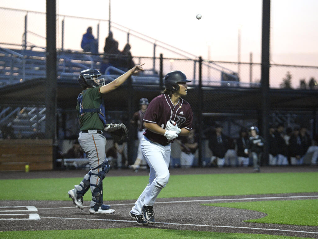 Ridgefield’s Jake Tsukada jogs to first base after drawing a walk against Cowlitz in the Raptors’ season-opening exhibition game against the Black Bears on Thursday, June 1, 2023, at Ridgefield Outdoor Recreation Complex.