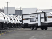 An RV porter moves travel trailers into place as General RV prepares for their sales event as customers prepare for another camping season, in Wixom, Mich., March 15, 2022.