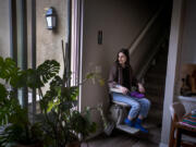 Courtney Gavin, at her Irvine, California home in February 2023, has been dealing with the effects of COVID-19 since March 2020 and uses a motorized lift to climb the stairs. (Allen J.