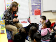 Students at a private Head Start school in Cobb County, Ga., react as Sally Miller, who works for the Marietta City Schools' public pre-K program, teaches them phonological awareness skills using a prop named Momo the monster. She visited the private school to coach its teachers.